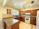Well-lit kitchen with updated cabinets, granite counters, tile backsplash, and white appliances at 5714 Garden Lakes Fern, Bradenton, FL 34203