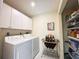 Laundry room featuring white washer and dryer, cabinets and wine rack and shelving at 5714 Garden Lakes Fern, Bradenton, FL 34203