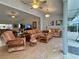 Bright living room with wood-look flooring, ceiling fans, and comfortable wicker furniture at 5714 Garden Lakes Fern, Bradenton, FL 34203