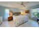 Bright bedroom featuring a ceiling fan, tile flooring, and two windows with views of the landscaping at 5714 Garden Lakes Fern, Bradenton, FL 34203