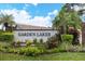 Community entrance sign that reads 'Garden Lakes', surrounded by lush landscaping on a sunny day at 5714 Garden Lakes Fern, Bradenton, FL 34203