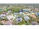 Scenic aerial view of a home surrounded by mature trees and a tranquil lake at 6114 Misty Oaks St, Sarasota, FL 34243