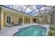 Relaxing backyard pool area with a hot tub, covered patio, and seamless indoor-outdoor living spaces at 6114 Misty Oaks St, Sarasota, FL 34243
