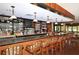 Upscale bar area with a marble countertop, wooden stools, beautiful hardwood floors, and a fully stocked bar at 6114 Misty Oaks St, Sarasota, FL 34243