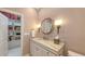 Elegant bathroom featuring marble countertops, unique lighting fixtures, and a convenient walk-in storage area at 6114 Misty Oaks St, Sarasota, FL 34243