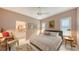 Bedroom with neutral colors featuring ceiling fan, plantation shutters, and adjacent bathroom at 6114 Misty Oaks St, Sarasota, FL 34243