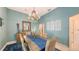Elegant dining room with a chandelier, blue walls, and a rustic wooden table set for dinner at 6114 Misty Oaks St, Sarasota, FL 34243