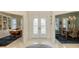 Open foyer features decorative double doors, tiled flooring, and views into a living room and dining room at 6114 Misty Oaks St, Sarasota, FL 34243