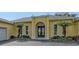 A beautifully landscaped home exterior featuring an arched doorway and a two-car garage at 6114 Misty Oaks St, Sarasota, FL 34243