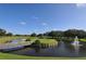 Scenic golf course view featuring lush green fairways, a water hazard with a fountain, and a charming wooden bridge at 6114 Misty Oaks St, Sarasota, FL 34243