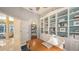 Bright home office with custom built-ins and a large wooden desk overlooking the front lawn at 6114 Misty Oaks St, Sarasota, FL 34243