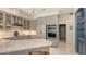Well-lit kitchen with gray cabinetry, stainless steel appliances, and marble countertops at 6114 Misty Oaks St, Sarasota, FL 34243