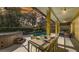 Relaxing screened-in lanai with a dining table, hot tub, and a view of the pool and lush backyard at 6114 Misty Oaks St, Sarasota, FL 34243