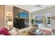 Living room featuring a fireplace, mounted TV, and sliding doors leading to an outdoor pool at 6114 Misty Oaks St, Sarasota, FL 34243