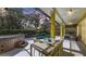 Outdoor dining area with table and chairs with view of screened-in pool, landscaping, and surrounding trees at 6114 Misty Oaks St, Sarasota, FL 34243