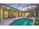 Screened-in pool area with comfortable seating, a hot tub, and sliding glass doors to the home's interior at 6114 Misty Oaks St, Sarasota, FL 34243