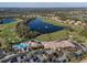 Panoramic aerial view of a lush golf course with a serene lake, resort-style pool, and upscale residential community at 6560 Willowshire Way, Bradenton, FL 34212