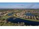 Aerial view of a planned community featuring houses around lakes with a golf course and lush landscaping at 6560 Willowshire Way, Bradenton, FL 34212