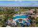 Expansive aerial view of a resort pool area surrounded by lush greenery, a golf course, and beautiful residential homes at 6560 Willowshire Way, Bradenton, FL 34212