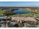 Aerial view of a clubhouse, pool, and golf course surrounded by a residential community, showing an active lifestyle at 6560 Willowshire Way, Bradenton, FL 34212