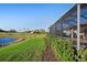 Lush backyard with view of golf course and lake beyond, providing a peaceful outdoor setting at 6560 Willowshire Way, Bradenton, FL 34212