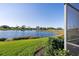 Serene backyard with lush green lawn and tranquil lake views, offering a private outdoor retreat at 6560 Willowshire Way, Bradenton, FL 34212