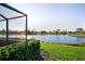 Scenic backyard featuring a lush lawn and a tranquil lake view from the screened-in lanai at 6560 Willowshire Way, Bradenton, FL 34212