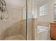 Bathroom featuring glass shower door and separate soaking tub with tiled surround at 6560 Willowshire Way, Bradenton, FL 34212
