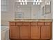 Well-lit bathroom vanity with double sinks, granite countertop, and a large mirror at 6560 Willowshire Way, Bradenton, FL 34212