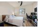 Bedroom with a ceiling fan, window, and wood-look floors; furnished with a bed and a gaming setup at 6560 Willowshire Way, Bradenton, FL 34212