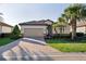 Charming single-story home featuring a tile roof, brick driveway, and lush landscaping at 6560 Willowshire Way, Bradenton, FL 34212