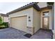 Two-car garage with brick facade and pavers, and elegant glass-panel front door at 6560 Willowshire Way, Bradenton, FL 34212