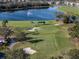 Scenic golf course with lush green fairways, sand traps, and a serene lake with fountain feature in the background at 6560 Willowshire Way, Bradenton, FL 34212
