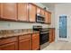 Close up of the kitchen featuring stainless steel appliances, granite countertops, and wood cabinets at 6560 Willowshire Way, Bradenton, FL 34212