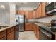 Corner view of the kitchen with stainless steel appliances, granite countertops, and wooden cabinetry at 6560 Willowshire Way, Bradenton, FL 34212