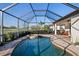 Sparkling screened-in pool and spa with lush landscaping and scenic golf course views at 6560 Willowshire Way, Bradenton, FL 34212