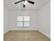 Neutral bedroom featuring a ceiling fan, tile flooring, and a bright window at 6639 Pineview Ter # 6639, Bradenton, FL 34203