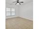 Minimalist bedroom with tile flooring, ceiling fan, and natural light from the window at 6639 Pineview Ter # 6639, Bradenton, FL 34203