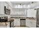 Well-lit kitchen features stainless steel appliances, marbled countertops, and white cabinetry at 6639 Pineview Ter # 6639, Bradenton, FL 34203