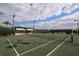 Well-maintained tennis court with nets, benches, and lighting surrounded by a secure fence at 6639 Pineview Ter # 6639, Bradenton, FL 34203