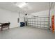 Spacious garage with an epoxy floor, featuring a roll-up door and plenty of storage at 7140 Woodville Cv, Bradenton, FL 34202