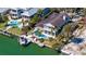 Aerial view of waterfront home with a private pool, dock, and boat lift, set in a lush, tropical landscape at 732 Siesta Dr, Sarasota, FL 34242