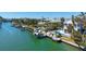 Overhead shot of a waterfront property featuring a private dock and lift, surrounded by serene water and lush greenery at 732 Siesta Dr, Sarasota, FL 34242