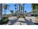 A luxurious home with a circular brick driveway lined with majestic palm trees and lush landscaping at 732 Siesta Dr, Sarasota, FL 34242