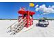 Bright red lifeguard stand on a sunny beach, equipped with umbrellas and safety gear at 732 Siesta Dr, Sarasota, FL 34242