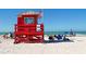 Red lifeguard stand with the American flag flying, positioned on a crowded beach at 732 Siesta Dr, Sarasota, FL 34242