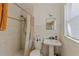 Bathroom featuring a pedestal sink, shower, and neutral tile surround at 747 Sunset Dr, Tarpon Springs, FL 34689