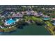 Aerial view of community clubhouse, pools, and verdant grounds with lake in foreground at 7649 Quinto Dr, Sarasota, FL 34238