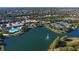 Scenic aerial view showcasing a large lake with a fountain, surrounded by lush landscaping, pool, and tennis courts at 7649 Quinto Dr, Sarasota, FL 34238