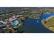 Aerial view showing clubhouse with pool, tennis courts, green areas and lake with fountain at 7649 Quinto Dr, Sarasota, FL 34238